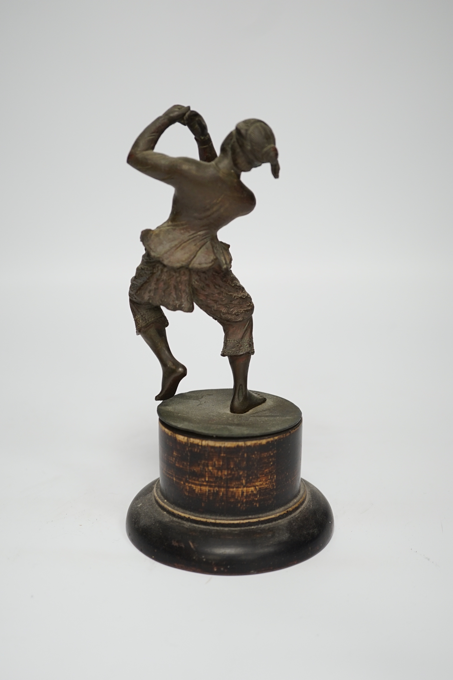 A small bronze figure of a Javanese dancer on a wooden base, 18.5cm